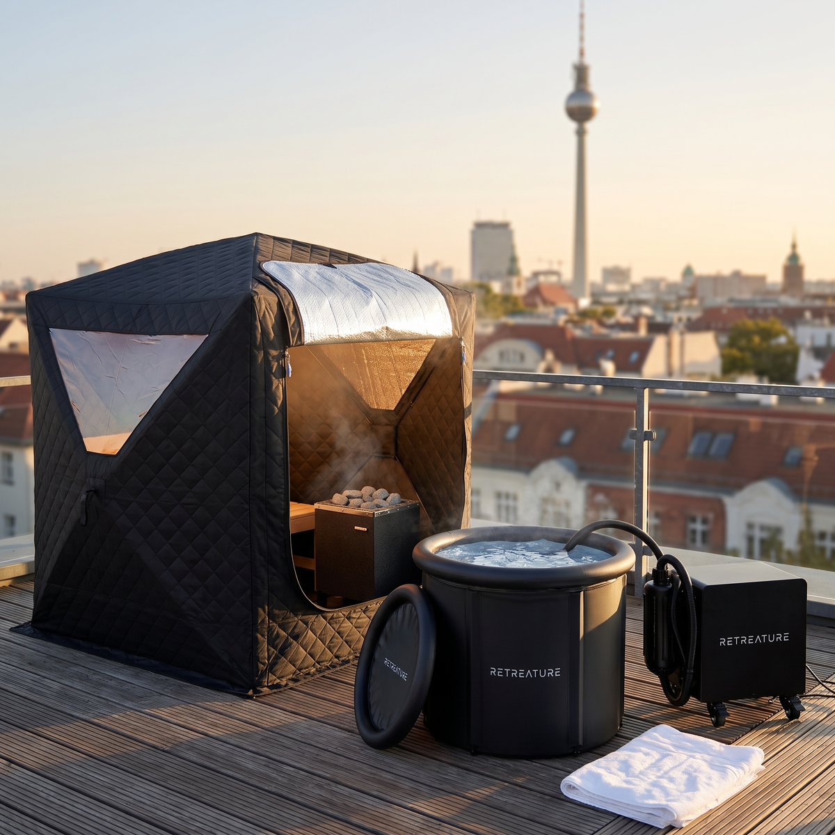 Sauna Cube, PolarPlunge Basic und ProCooler 2.0 nebeneinander auf der Dachterrasse, im Hintergrund der Berliner Fernsehturm